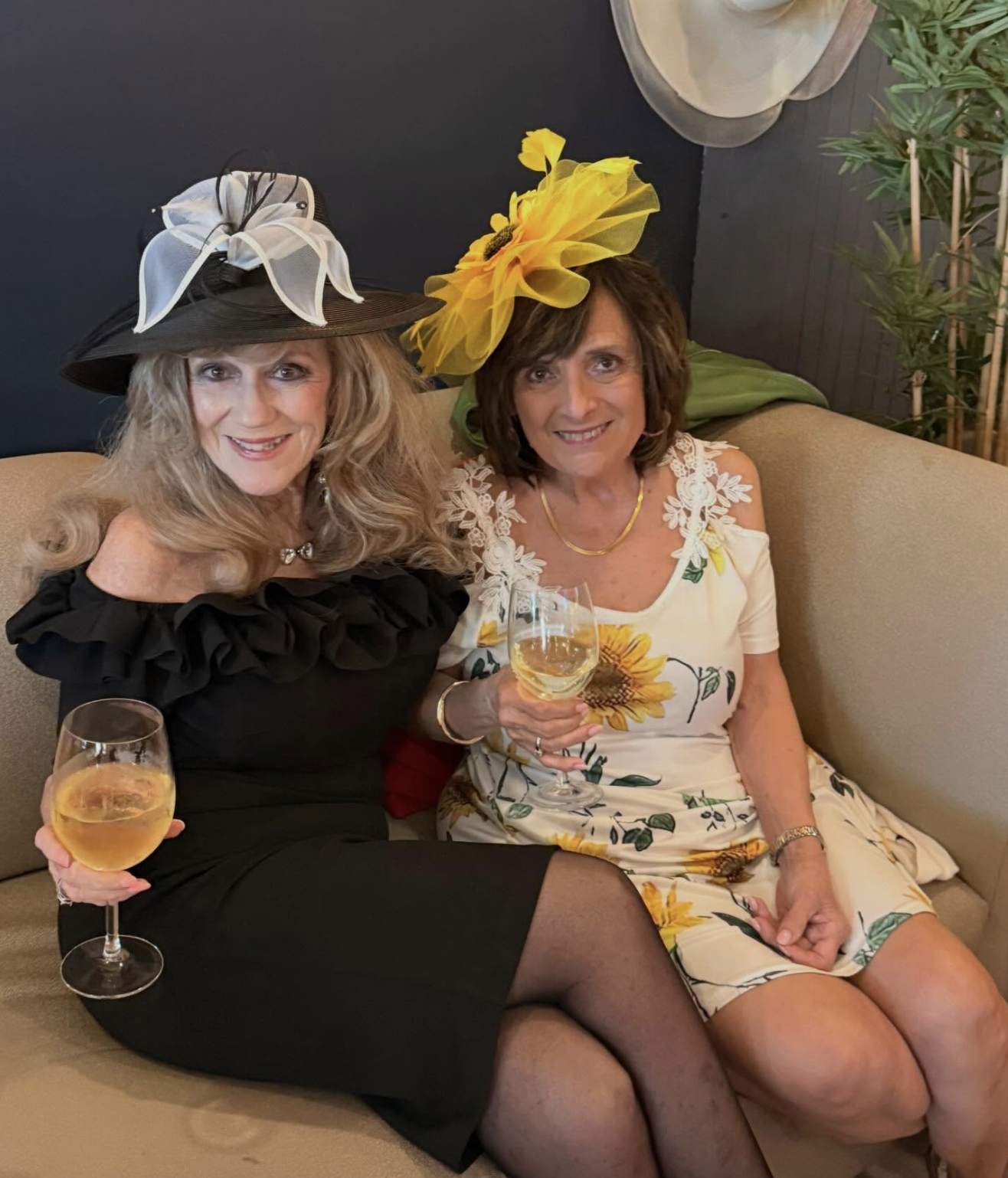Friends in dresses and hats sharing wine