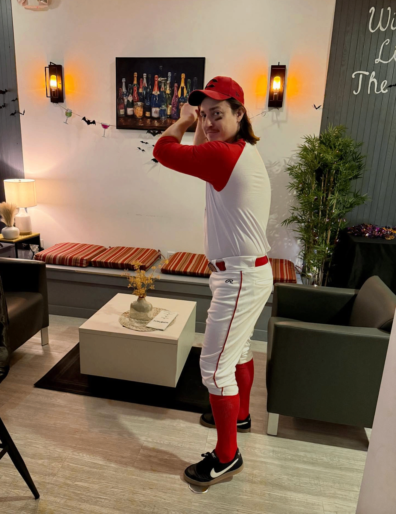 Guest in baseball uniform posing at the Hallowine costume party