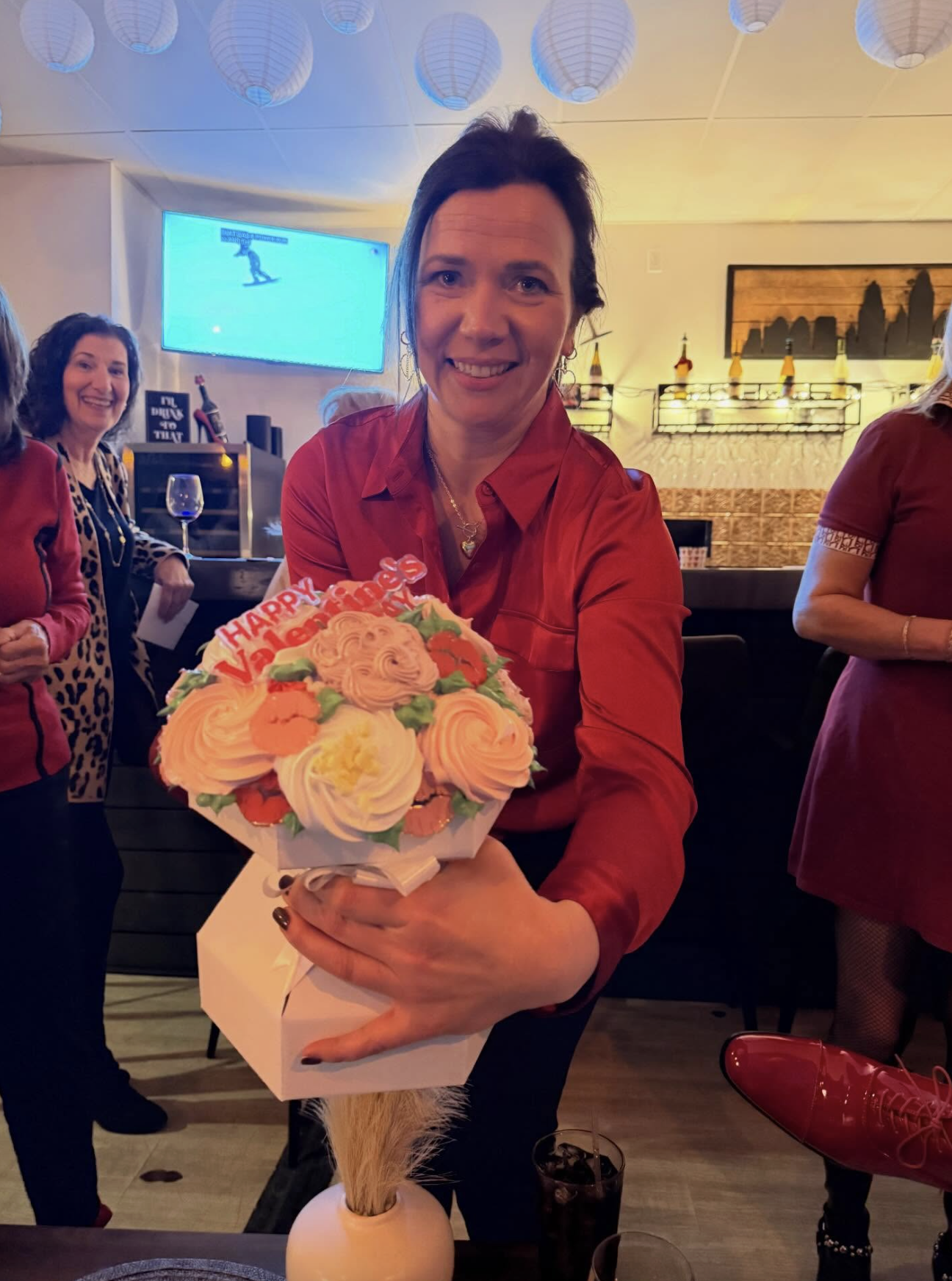 Guest holding a Happy Valentines cupcake bouquet at the wine bar