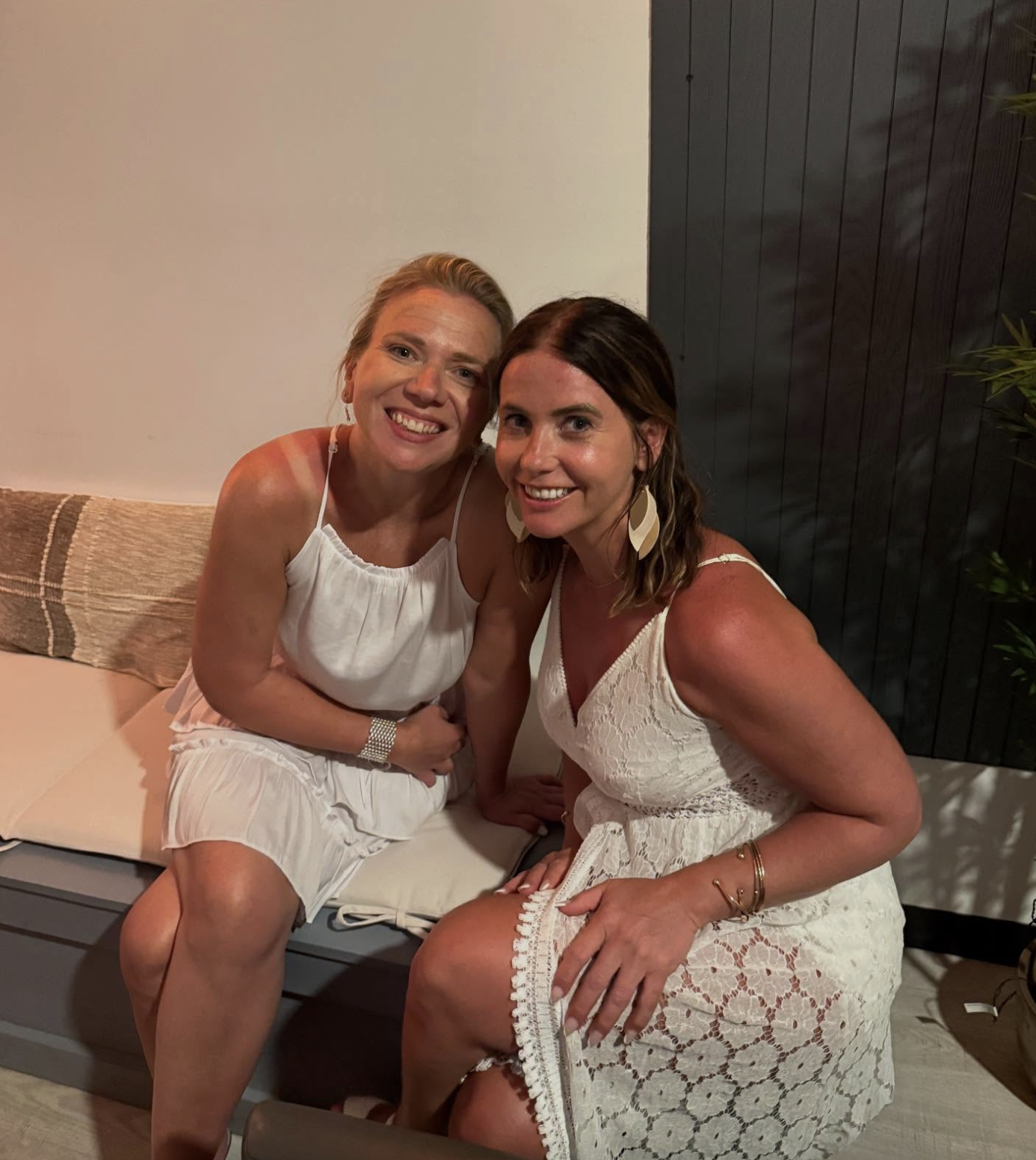 Two friends in white sundresses on the lounge