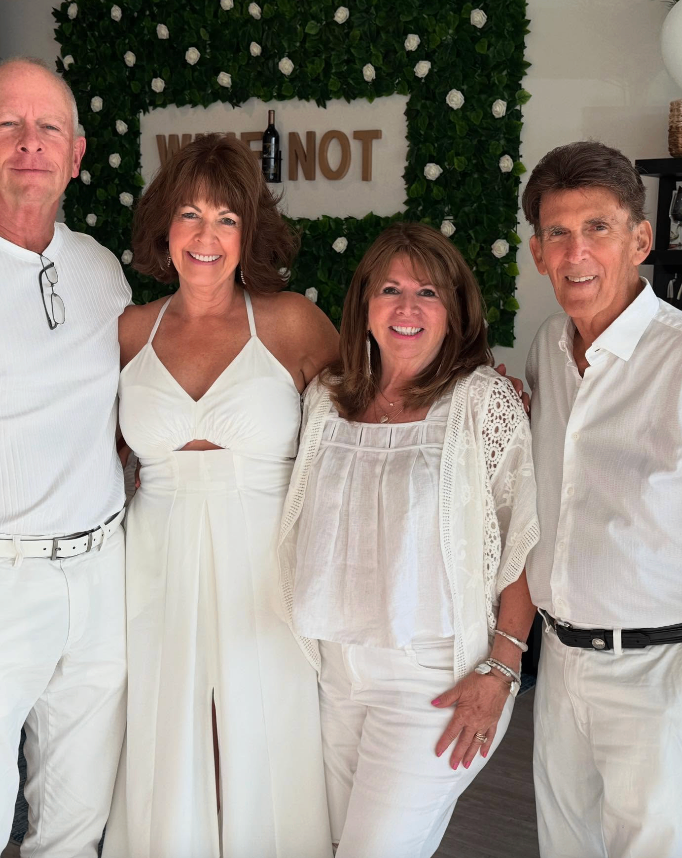 Four guests in all-white at the White Wine & Attire party